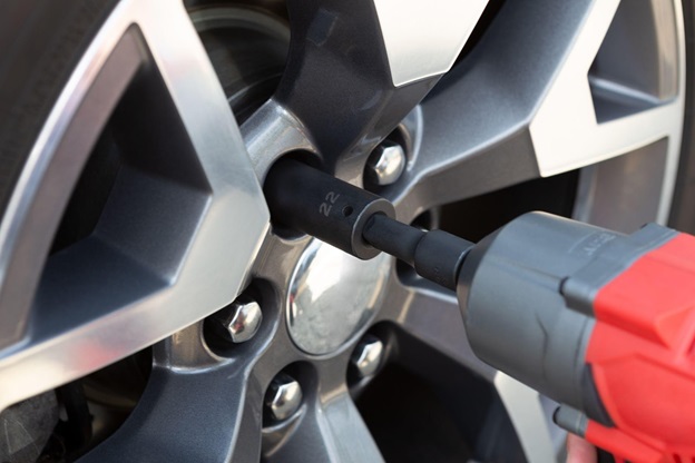 A drill tightens lugnuts, a service offered by CarGuard